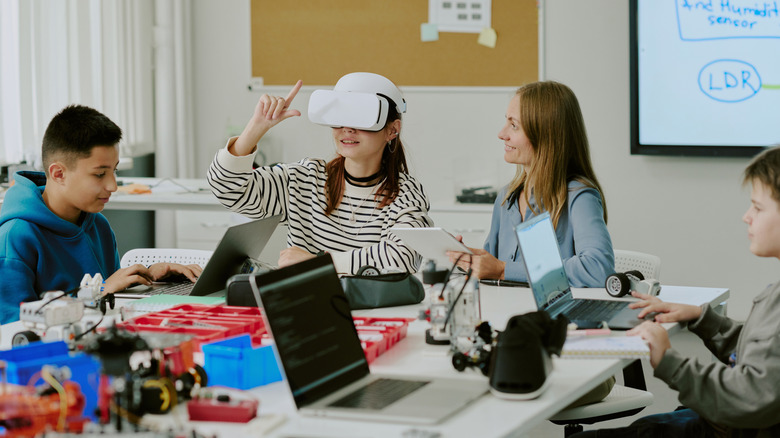 Kids in a classroom hang out with a VR headset