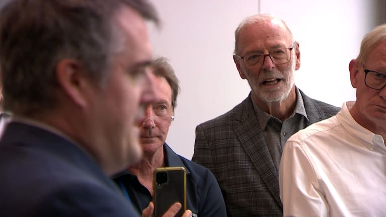 Wayne Brown watches on as Chris Bishop speaks to the media. 