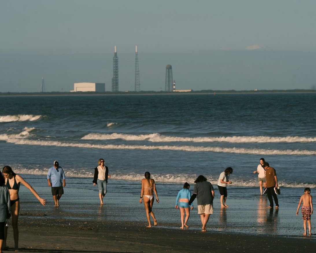 Beachgoers enjoy the sand and surf of Cocoa Beach, Florida, in January as launchpads loom nearby on Cape Canaveral.