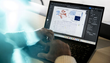 A pair of hands at a laptop that displays a multifunctional user interface.