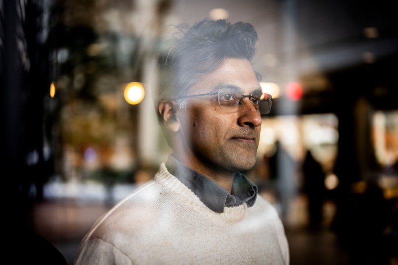 Portrait of Kiran Vanaja, looking through a window.