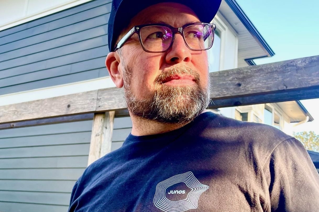 Andrés Mendoza, vice-president of the Canadian Academy of Recording Arts and Sciences, in a baseball cap and wearing a shirt with a Juno logo on it.