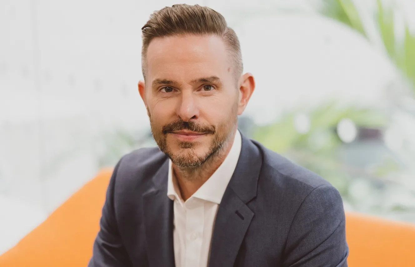 Dax Harkins in a suit jacket and white shirt.