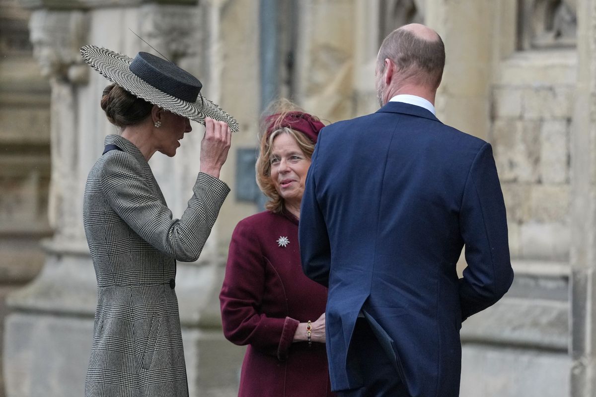 Kate held on to her large hat in the windy weather 