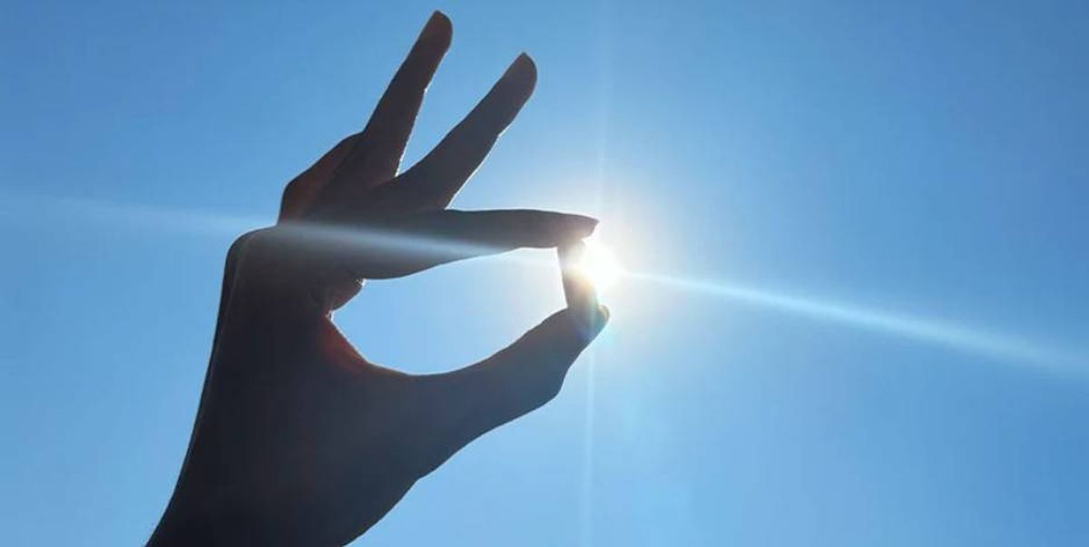 Someone holding a capsule up against sunlight