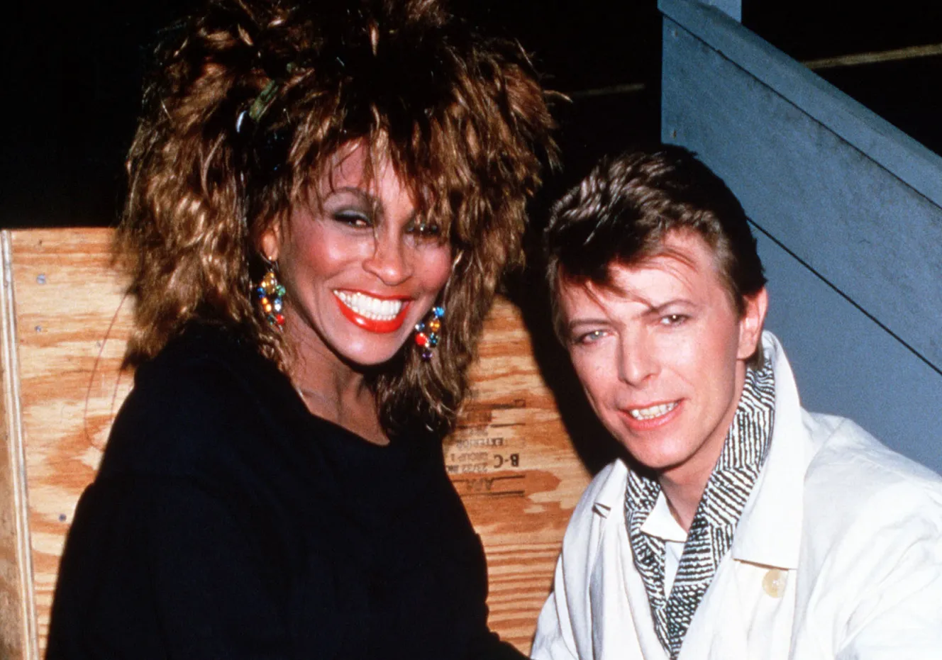 Tina Turner and David Bowie sitting backstage.