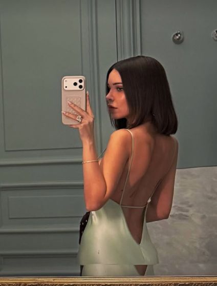 Jackie Apostle in a mini-green backless dress