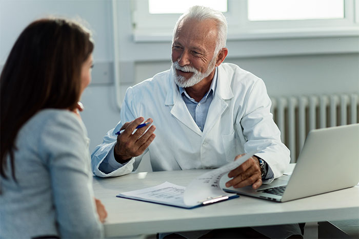 Doctor sharing behind-the-scenes insights and feelings with patient during a private consultation in medical office.