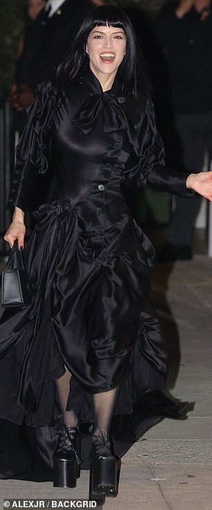 Bringing the motif together with a raven shade of nail polish, she appeared in bright spirits as she arrived at the fete, smiling radiantly