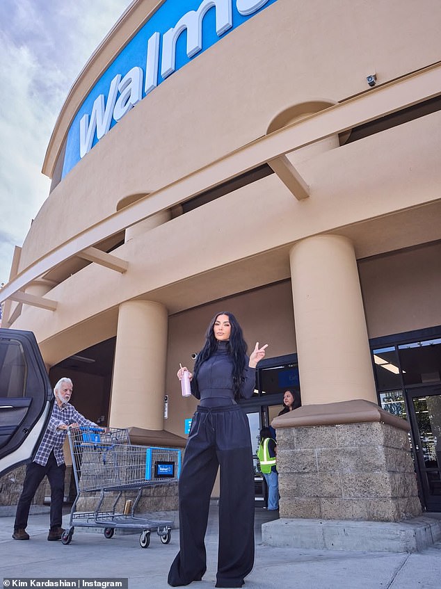She wore an all-black outfit with the nylon pants pulled low to show off her slim waistline as she posed outside of Walmart and threw up a peace sign