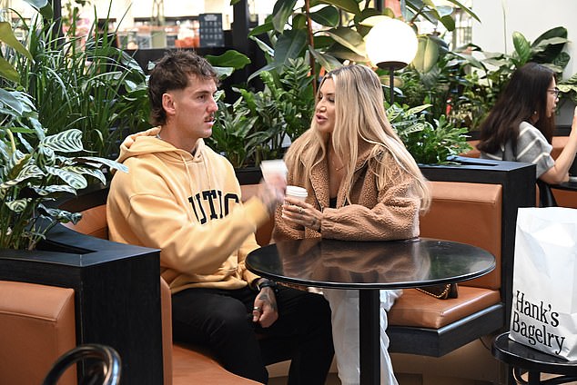 The pair appeared completely at ease during a cosy café date in Chadstone Shopping Centre in Melbourne, sitting side-by-side in a leafy venue as they chatted over takeaway coffees