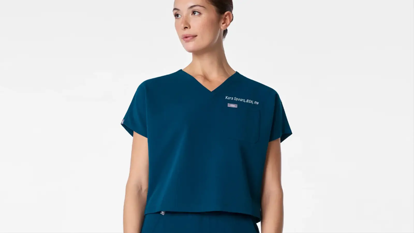 A photo of a woman wearing a FIGS cropped scrub top.