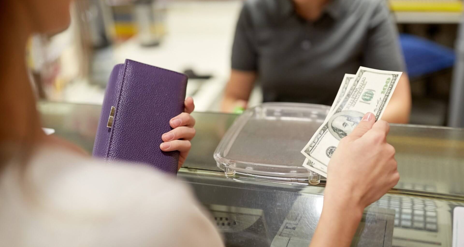 a woman holding cash and her wallet