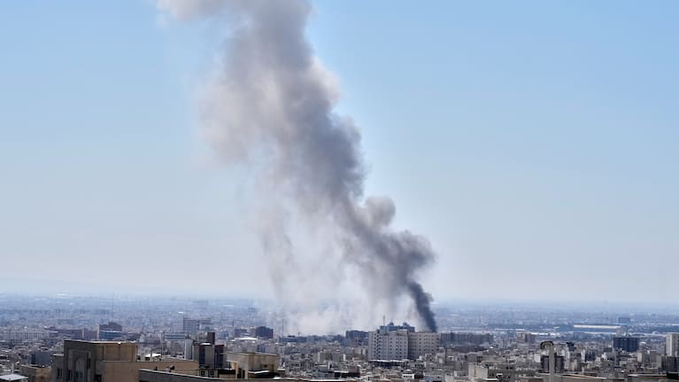 A plume of smoke rises after a strike in Tehran, Iran.