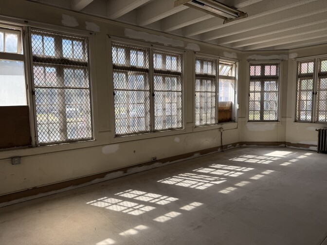 The interior of a room with large windows.