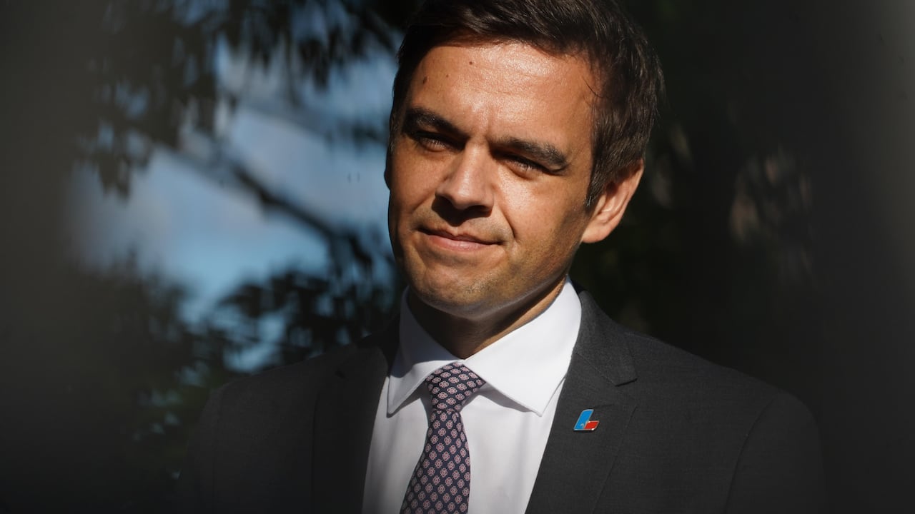 Close up shot of a man in business attire standing outside. 