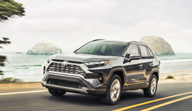 Toyota RAV4 driving down the road with a beach in the background.