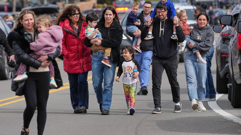 Law enforcement escort families with children away from the Temple Israel synagogue in Michigan 