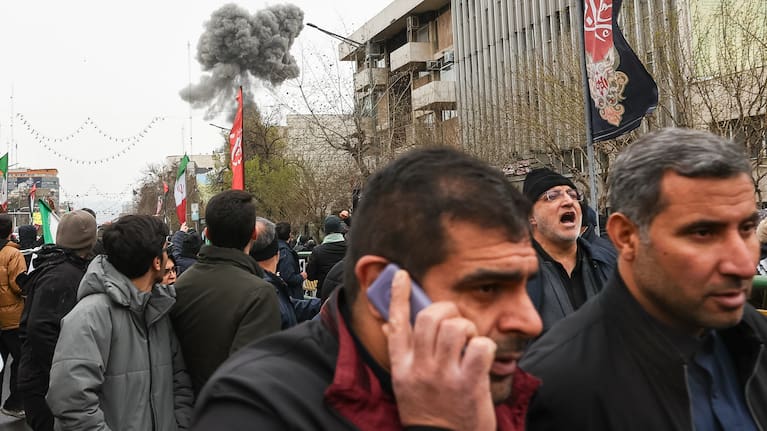 Smoke from an explosion rises behind demonstrators attending the annual anti-Israeli Quds Day, or Jerusalem Day, rally in support of Palestinians in Tehran, Iran, Friday, March 13, 2026. 