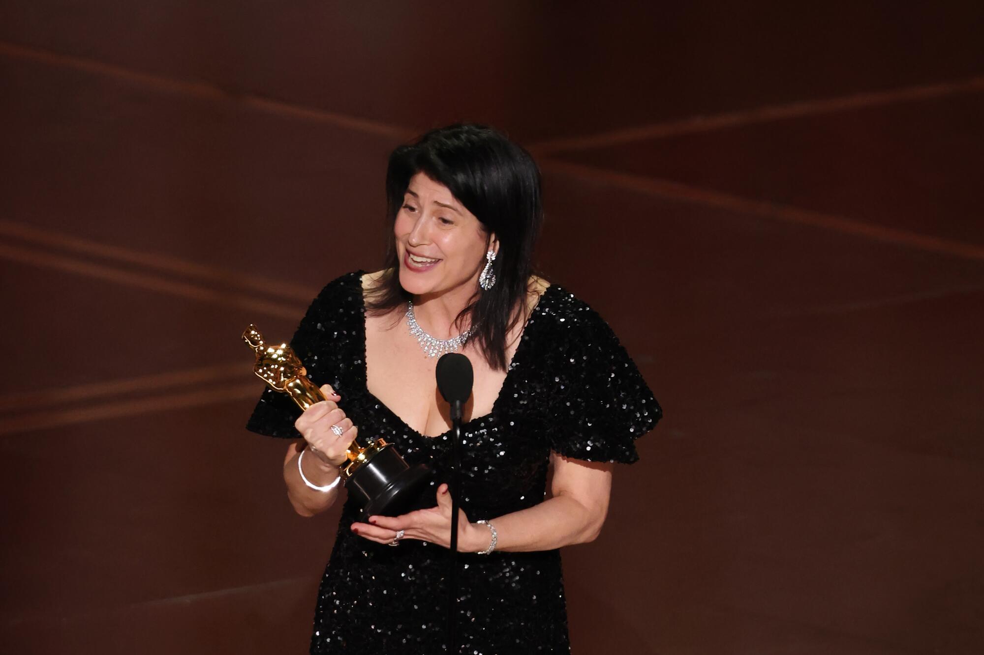 a woman on stage with a trophy
