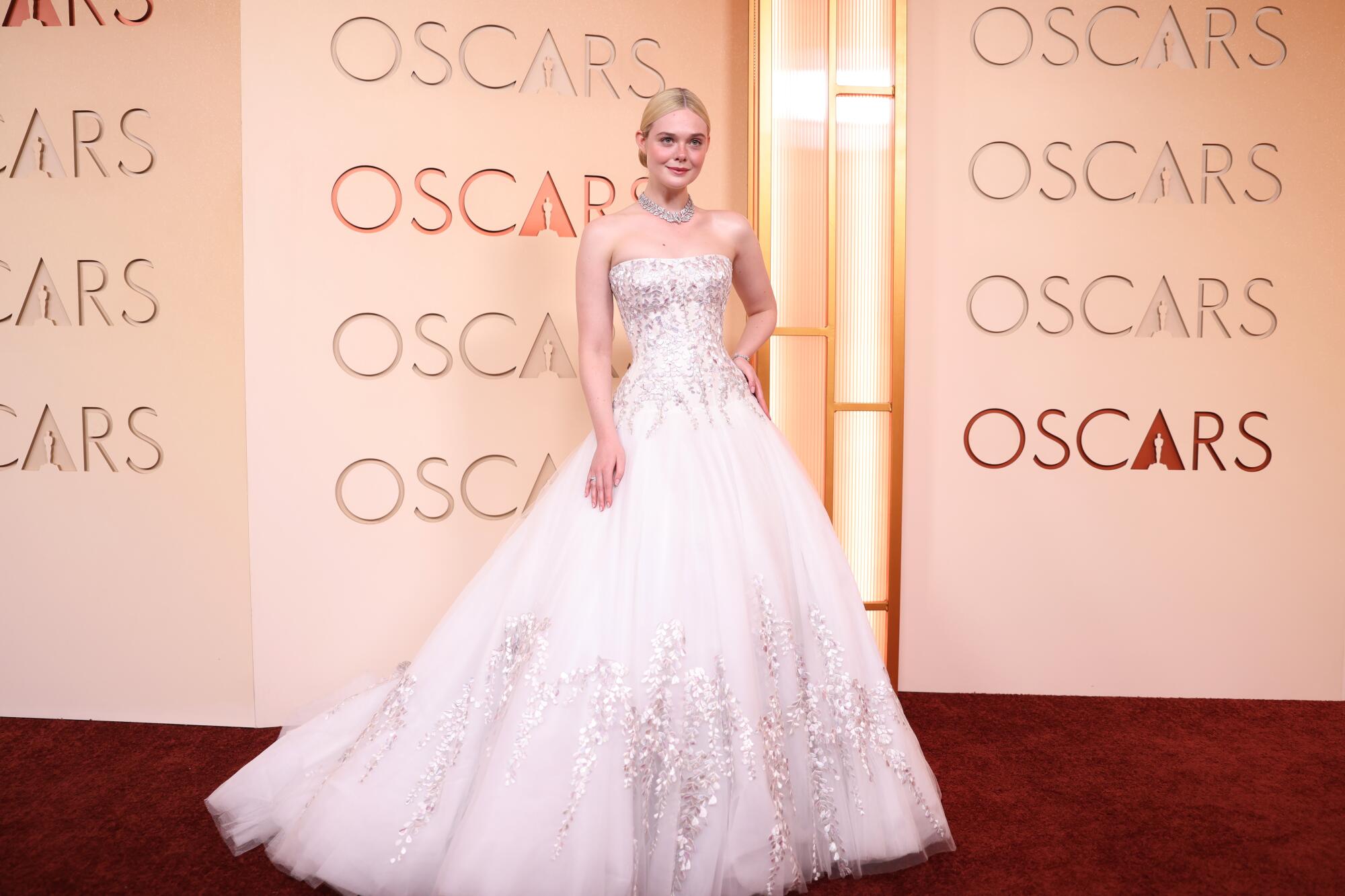 Elle Fanning arrives on the red carpet in a white sparkly ball gown