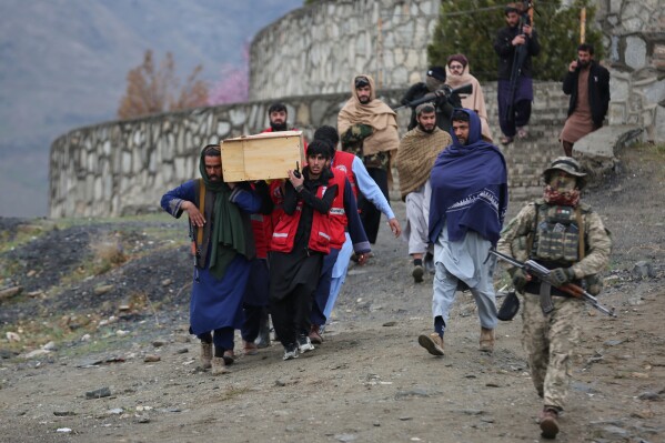 Taliban security personnel guard people carrying the remains of victims of a Monday airstrike on a drug rehabilitation hospital, ahead of burial in Kabul, Afghanistan, on Wednesday, March 18, 2026. (AP Photo/Siddiqullah Alizai)