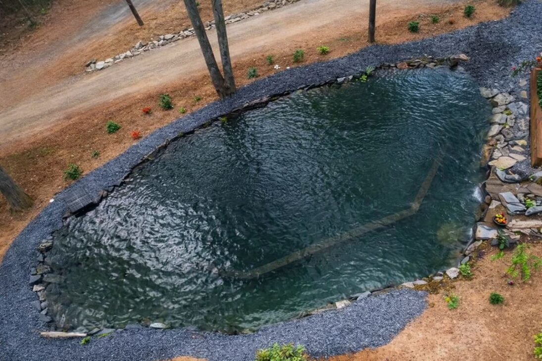 A natural pool with an excavation, waterfall, biological filter, and giant rocks shows how the island has become a bathing area.