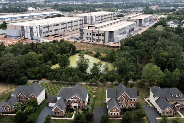 In an aerial view, an Amazon Web Services data center is shown situated near single-family homes on July 17, 2024 in Stone Ridge, Virginia.