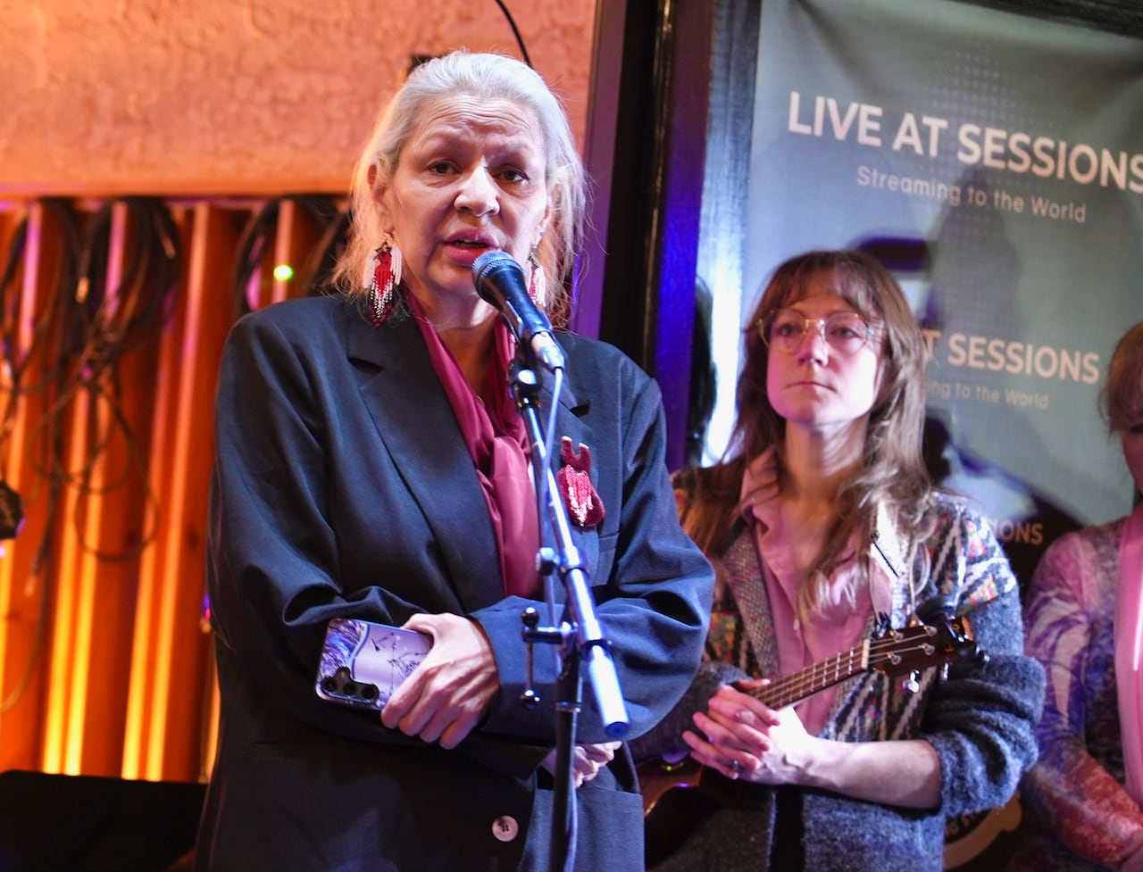 A woman speaks on a stage.
