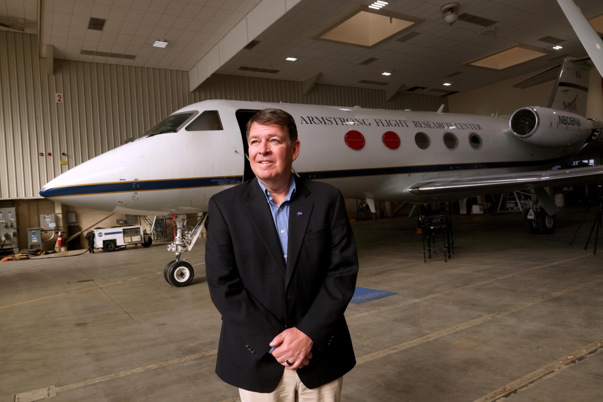 Armstrong Flight Research Center Director Brad Flick stands next to a Gulfstream III airplane