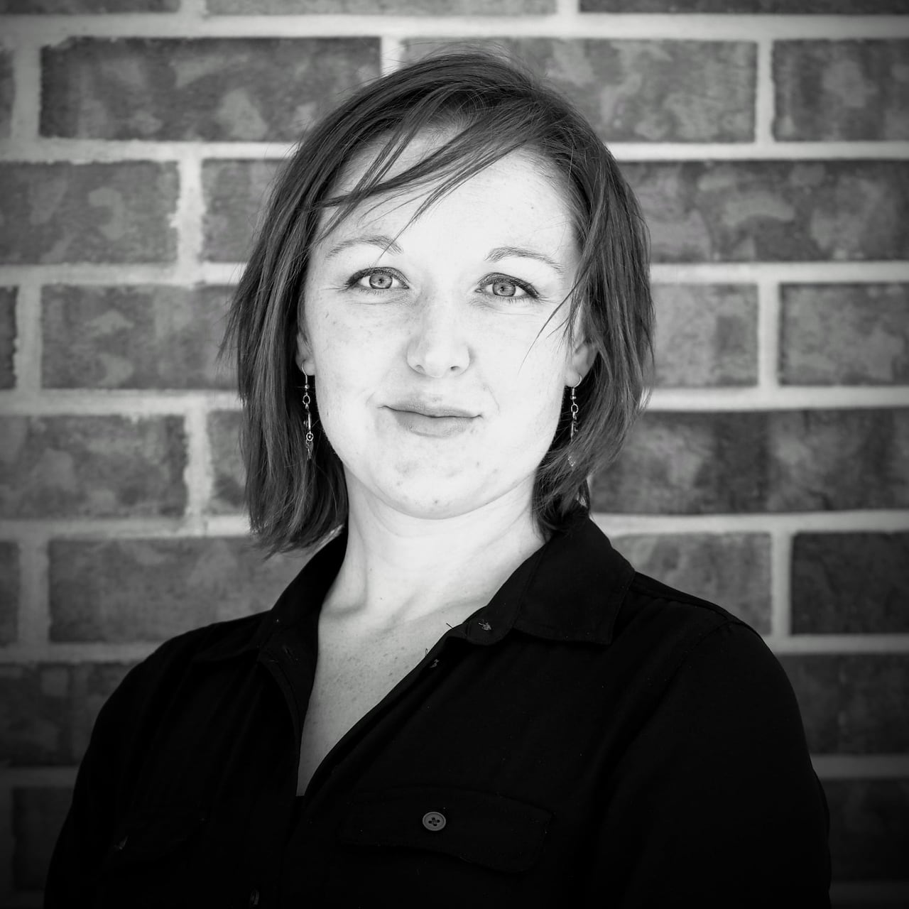 A woman with a neutral expression who has short hair and bangs.