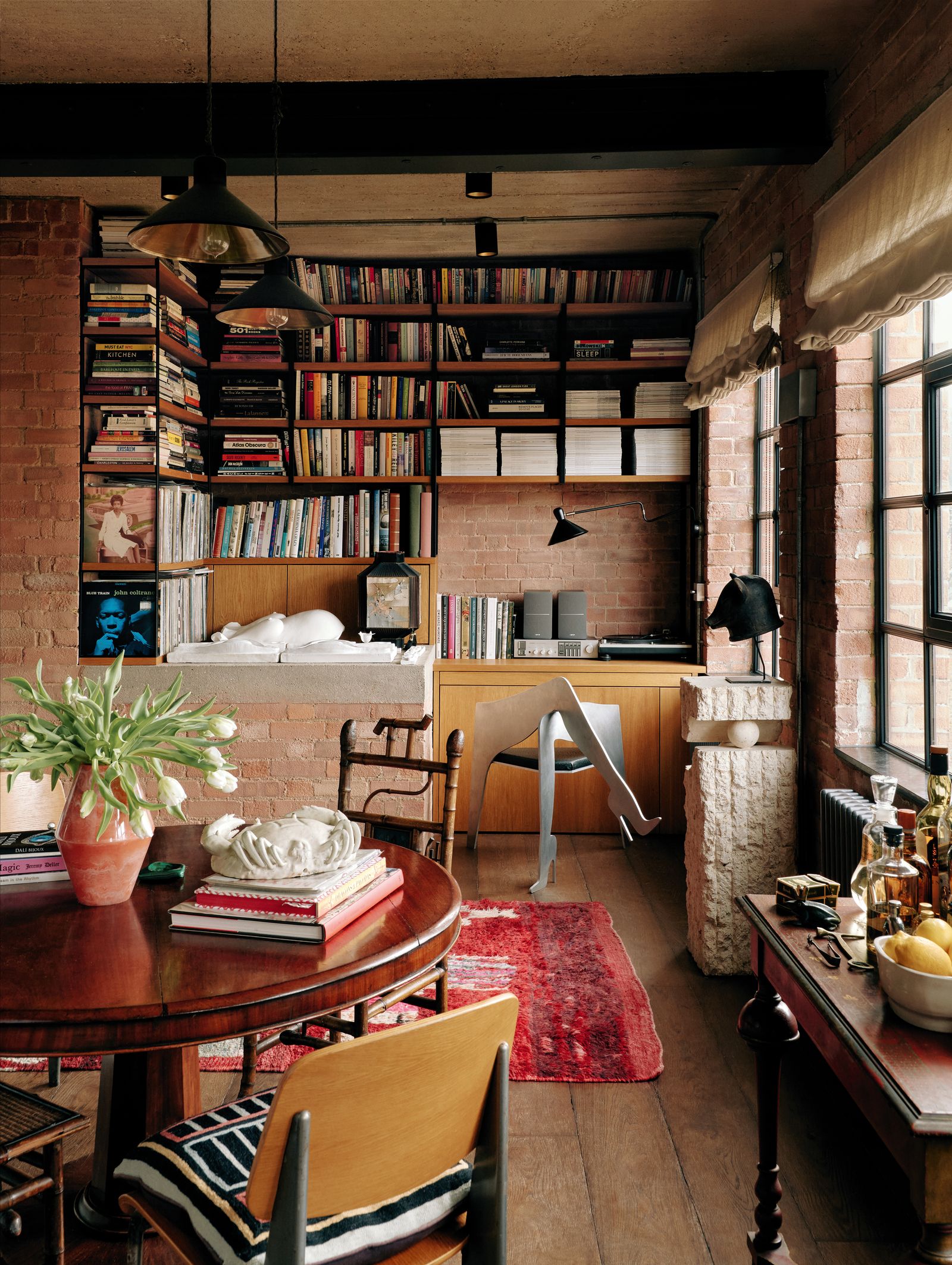 Image may contain Plant Home Decor Furniture Table Chair Indoors Interior Design Bookcase Person and Architecture