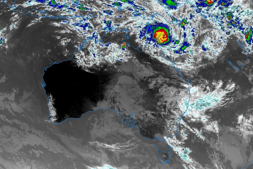 Black and white satellite image of Australia with large coloured circular area where the cyclone is