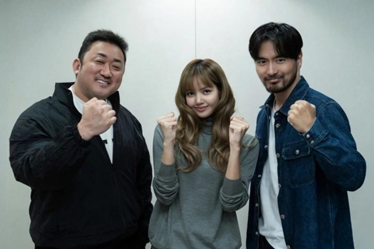 Lisa, center, with Ma Dong-seok, left, and Lee Jin-wook / Courtesy of Netflix