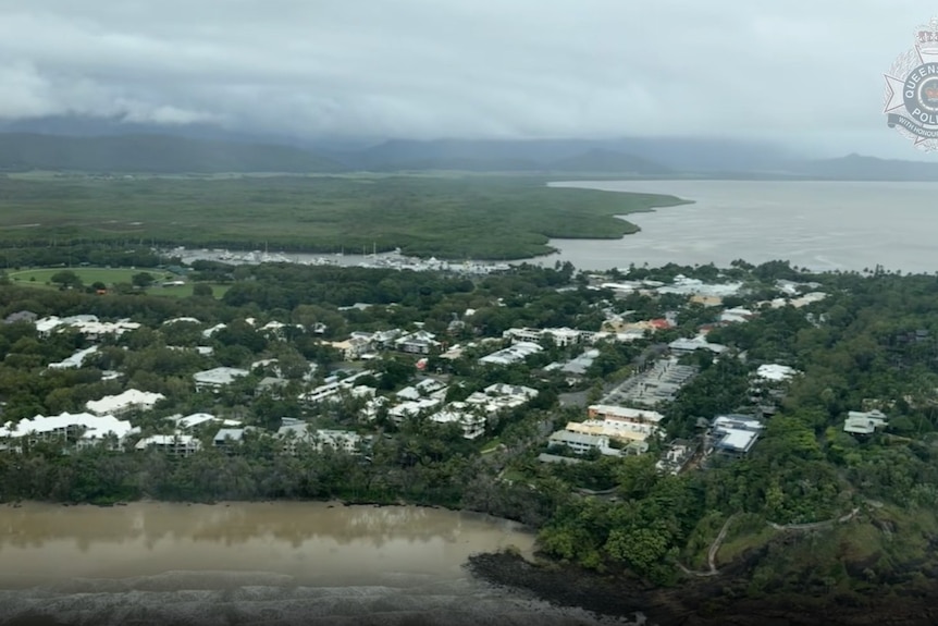 An aerial photo of a town showing houses, bushland and a river.