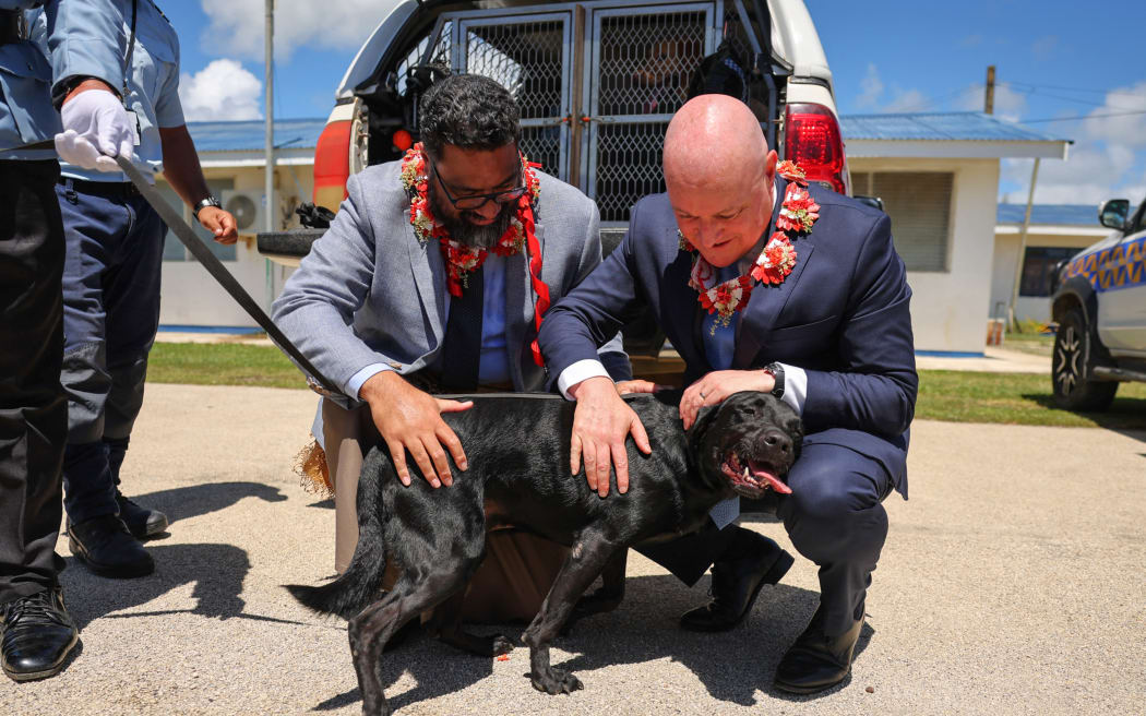 New Zealand's Prime Minister Christopher Luxon (R) and Tonga's Prime Minister Lord Fatafehi Fakafanua meet a drug sniffing dog during a police and transnational crime event in Nuku'alofa on March 18, 2026. (Photo by Ben STRANG / AFP)