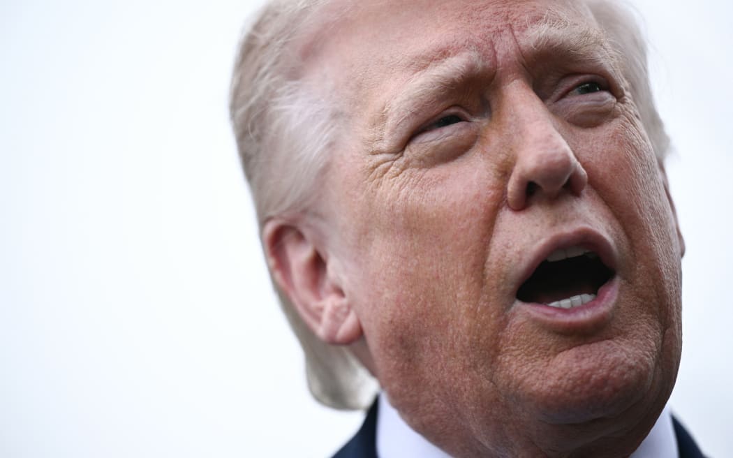 US President Donald Trump speaks to journalists before boarding Marine One as he departs from the South Lawn of the White House in Washington, DC, on March 20, 2026 for his Mar-a-Lago residence, where he will spend the weekend. (Photo by Brendan SMIALOWSKI / AFP)