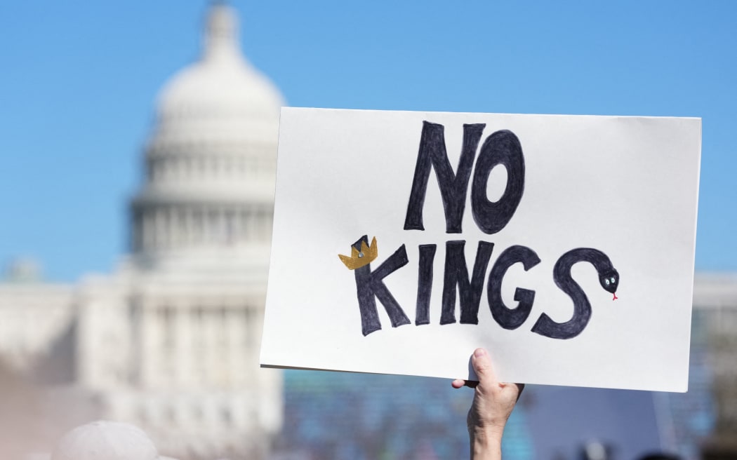 A person holds up a sign reading 