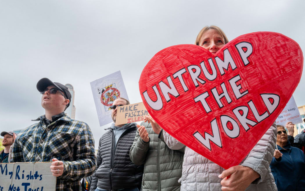 DALLAS, TEXAS - MARCH 28: People rally at the Dallas City Hall Plaza in protest against the Trump administration during a 