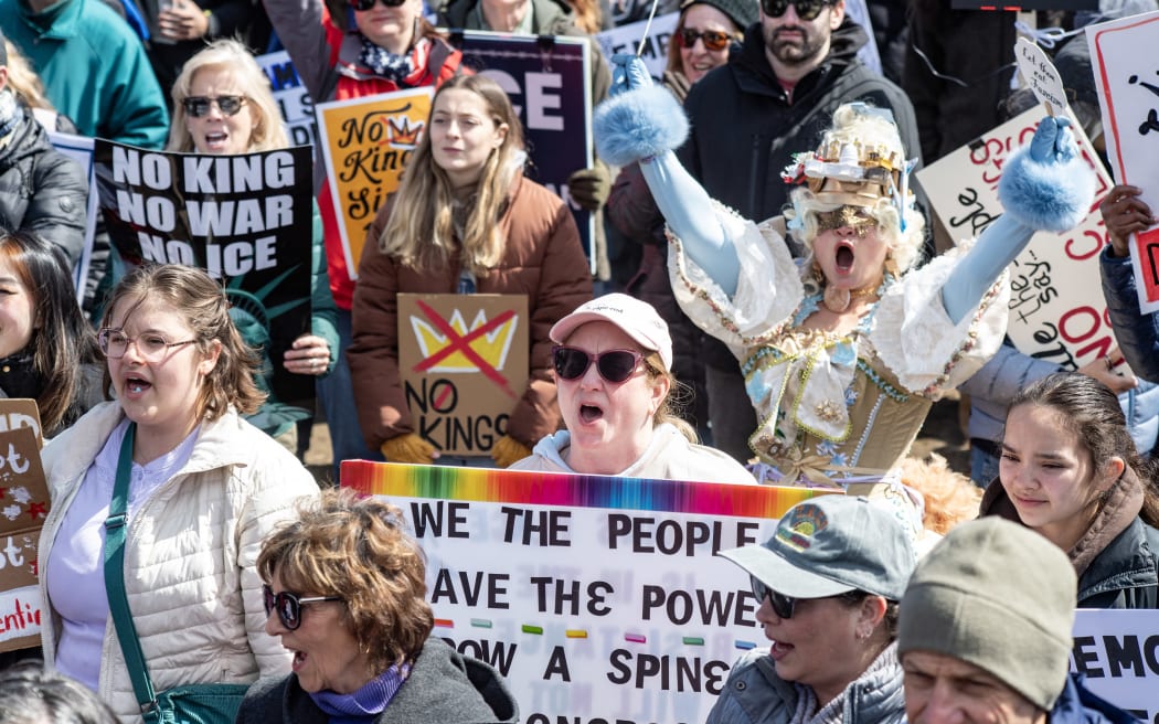 People hold signs as they gather at Boston Common during the 
