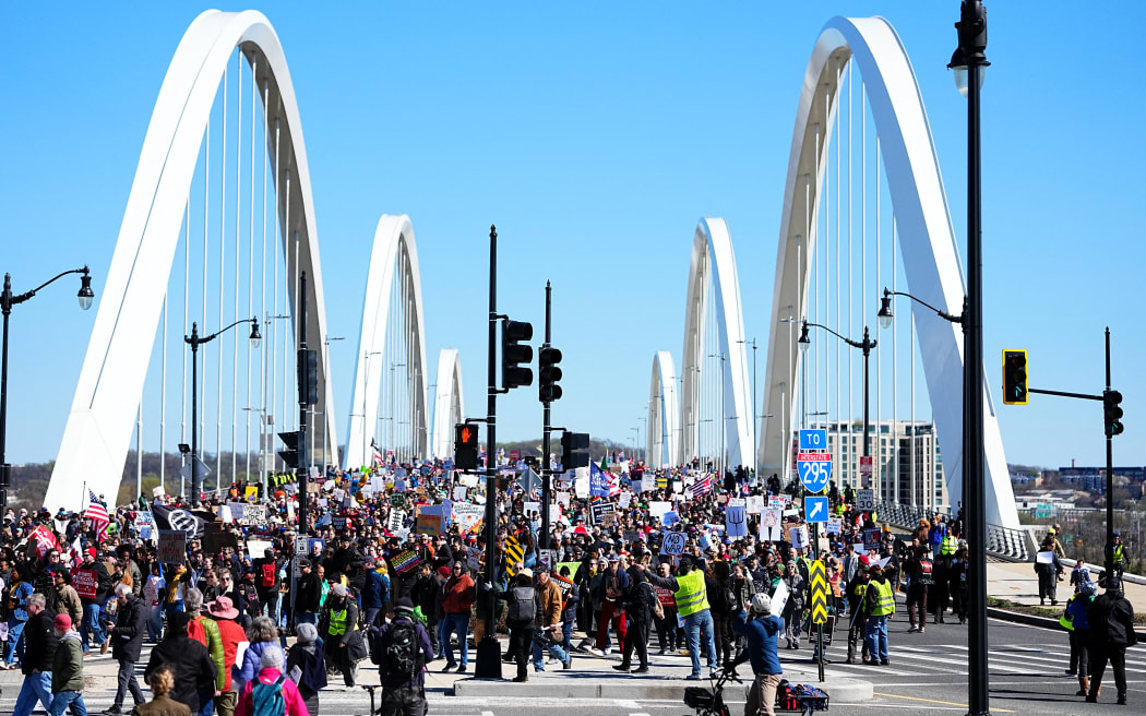 People march across the Frederick Douglass Bridge during the 