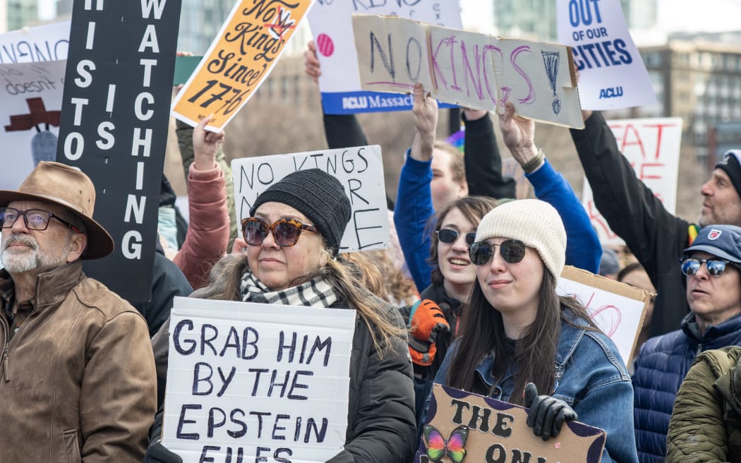 A person holds a sign reading 
