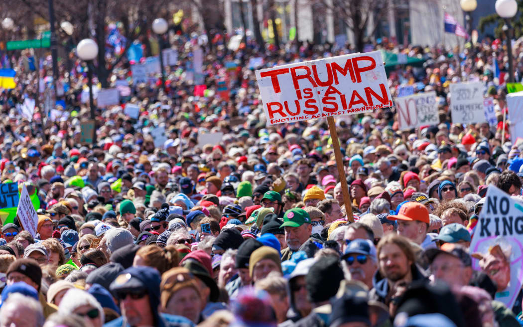 A person holds a sign reading 
