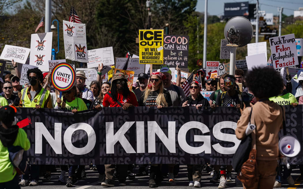 People hold a banner and signs as they march near the Georgia state Capitol building during the 