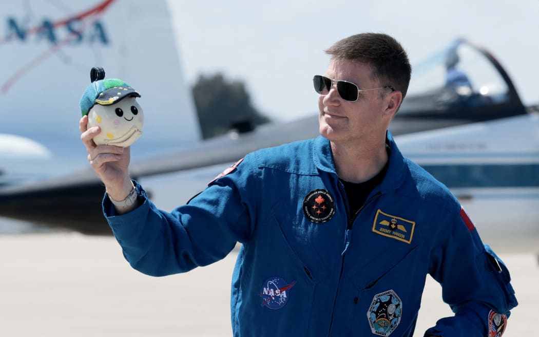 CAPE CANAVERAL, FLORIDA - MARCH 27: Artemis II crew mission specialist Jeremy Hansen of CSA (Canadian Space Agency) holds a plush toy of the 