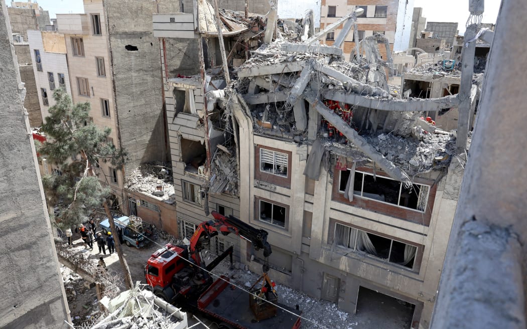 Firefighters look for victims and inspect damages at a residential building in southern Tehran on March 27, 2026, nearly a month into the Middle East war.