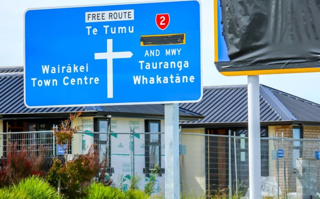 Covered road signs near the intersection of the Pāpāmoa East Interchange.