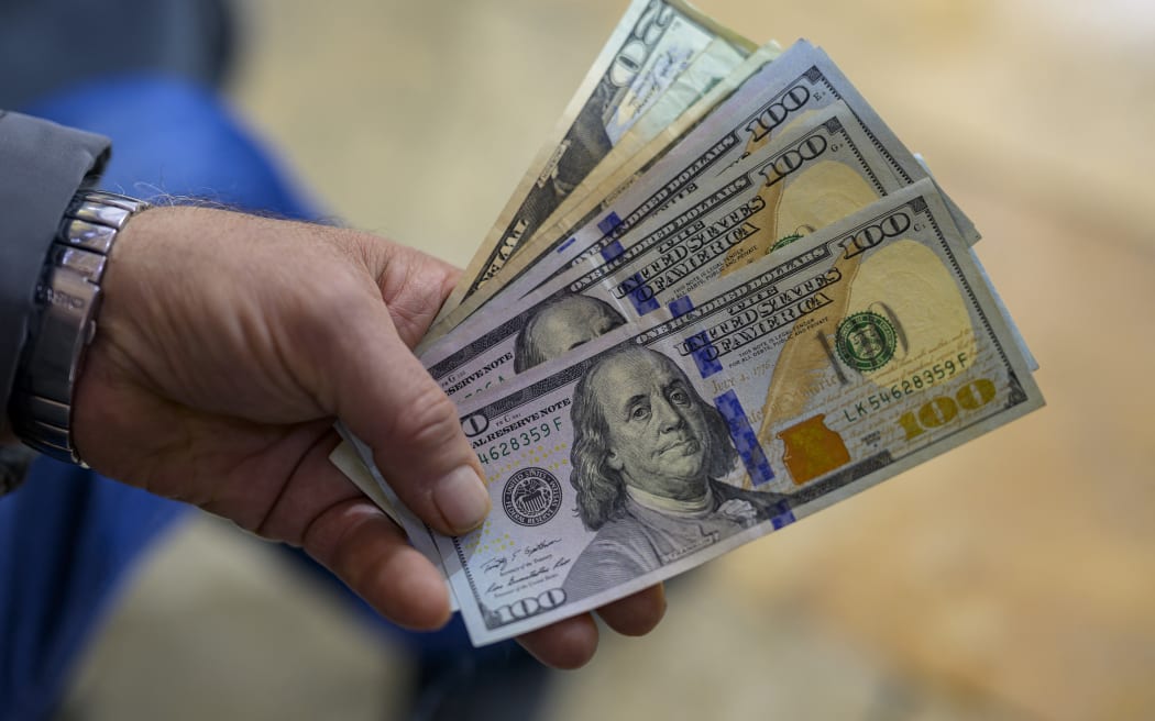 A teller shows US dollar bills at an exchange office at the Grand Bazaar in Istanbul on November 28, 2024. In recent weeks, the Turkish market has been increasingly unsettled by growing concerns over the circulation of counterfeit $50 and $100 bills.