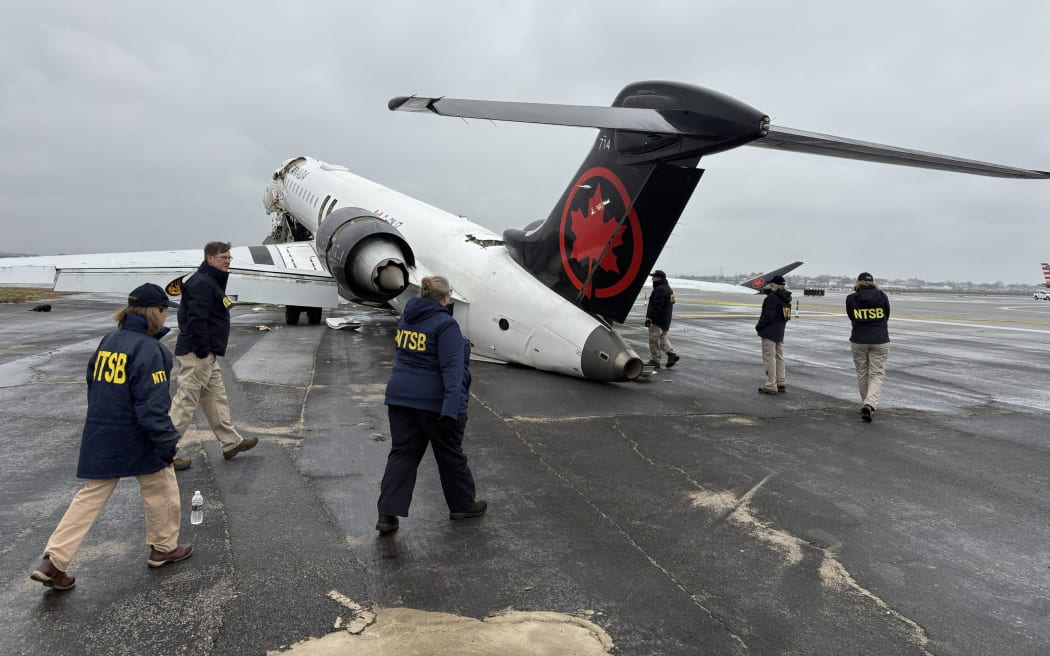 NTSB investigators at the scene of collision between an Air Canada Express plane and a firefighting vehicle at LaGuardia Airport on Monday, March 23.