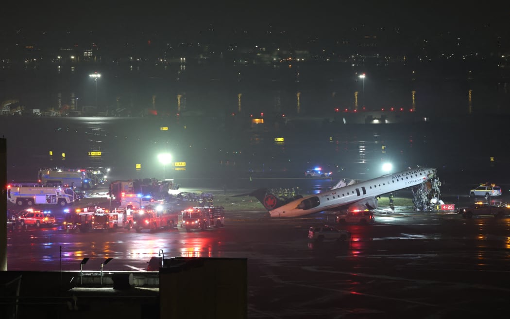 Emergency personnel respond to an Air Canada Express CRJ-900 that is sitting on the runway after colliding with a Port Authority fire truck at LaGuardia Airport in New York, on March 23, 2026. Air Canada Express flight AC8646 originated from Montreal and collided with the fire truck during landing. (Photo by ANGELA WEISS / AFP)